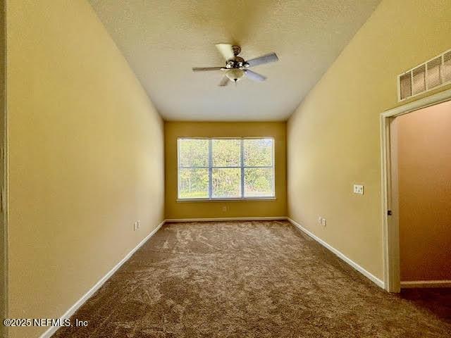 8561 Little Swift Cir Unit 32D, Jacksonville, FL 32256 - carpeted empty room featuring a ceiling fan, baseboards, and a textured ceiling