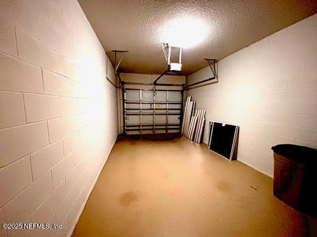 8561 Little Swift Cir Unit 32D, Jacksonville, FL 32256 - garage featuring concrete block wall and a garage door opener