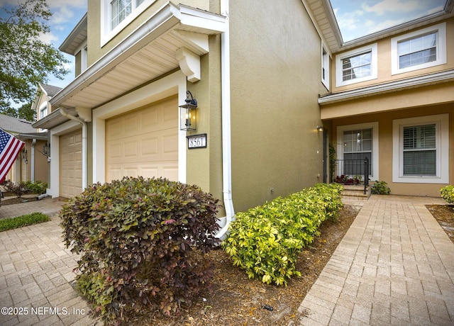 8561 Little Swift Cir Unit 32D, Jacksonville, FL 32256 - doorway to property featuring stucco siding and an attached garage