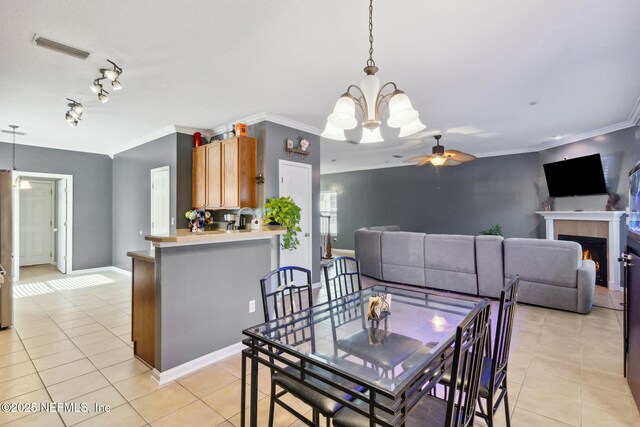 96290 Coral Reef Rd, Yulee, FL 32097 - dining room featuring light tile patterned floors, ceiling fan, crown molding, a chandelier, and a tile fireplace