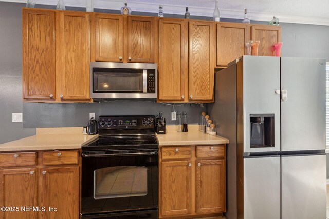 96290 Coral Reef Rd, Yulee, FL 32097 - kitchen with stainless steel appliances, light countertops, and brown cabinets