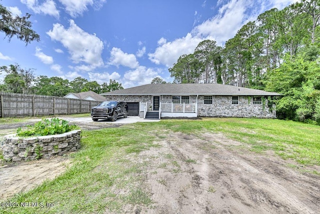 4966 Harvey Grant Rd, Fleming Island, FL 32003 - rear view of property featuring asphalt driveway, stone siding, a porch, and a garage
