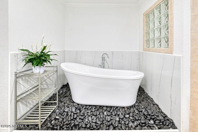 4966 Harvey Grant Rd, Fleming Island, FL 32003 - full bath featuring a freestanding bath, wainscoting, ornamental molding, and tile walls