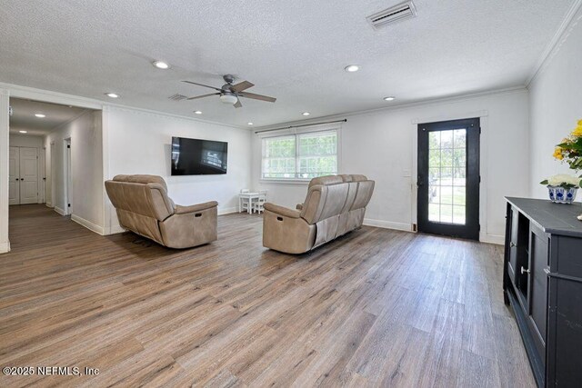 4966 Harvey Grant Rd, Fleming Island, FL 32003 - living area with plenty of natural light, light wood-type flooring, ornamental molding, a ceiling fan, and a textured ceiling