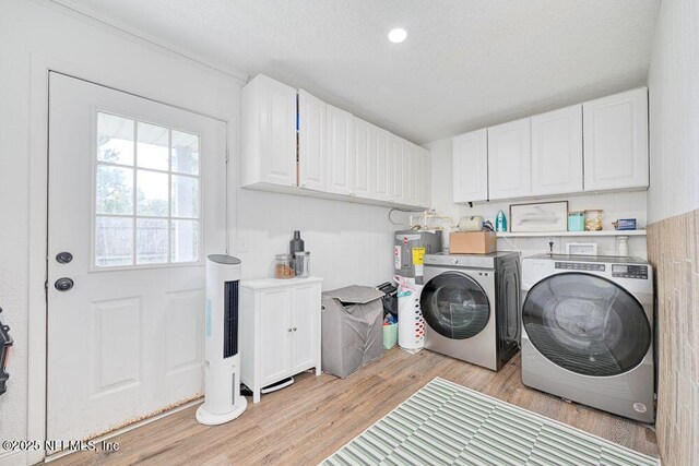 4966 Harvey Grant Rd, Fleming Island, FL 32003 - laundry area featuring separate washer and dryer, electric water heater, light wood finished floors, a textured ceiling, and cabinet space