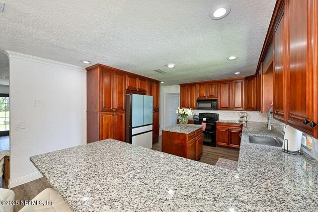 4966 Harvey Grant Rd, Fleming Island, FL 32003 - kitchen featuring black appliances, a sink, ornamental molding, wood finished floors, and light stone counters