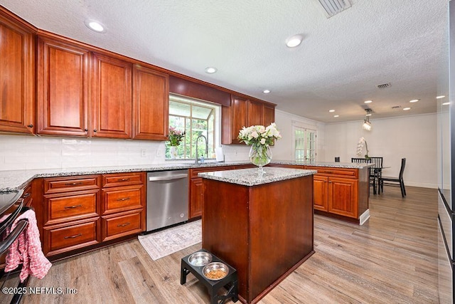 4966 Harvey Grant Rd, Fleming Island, FL 32003 - kitchen featuring stainless steel dishwasher, light wood-type flooring, a sink, a textured ceiling, and a center island