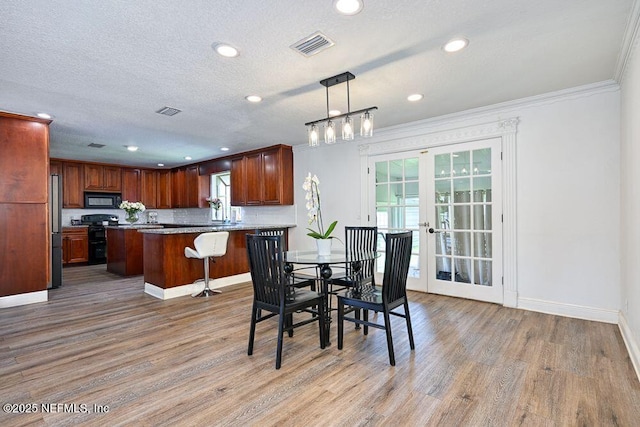 4966 Harvey Grant Rd, Fleming Island, FL 32003 - dining room featuring light wood-style flooring, french doors, baseboards, recessed lighting, and crown molding