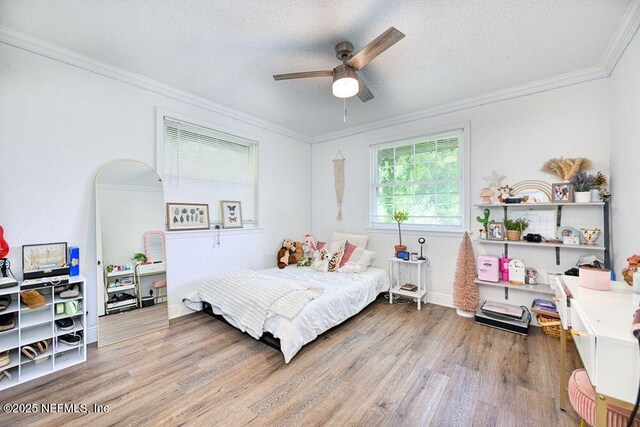 4966 Harvey Grant Rd, Fleming Island, FL 32003 - bedroom featuring wood finished floors, ornamental molding, a textured ceiling, ceiling fan, and baseboards