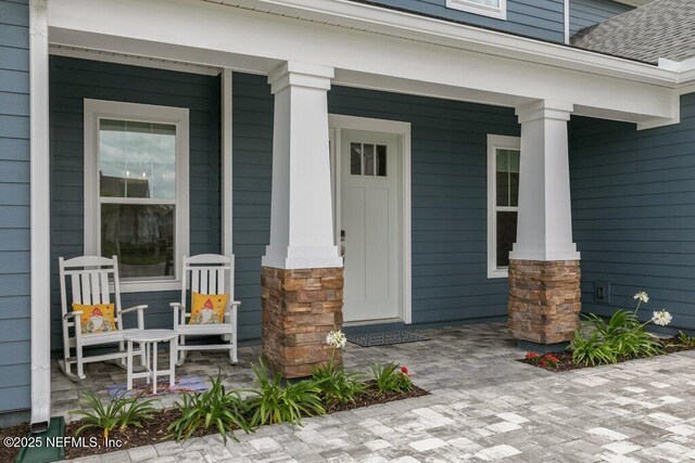 105 Awlleaf Ct, Saint Augustine, FL 32095 - view of exterior entry featuring a porch, stone siding, and roof with shingles