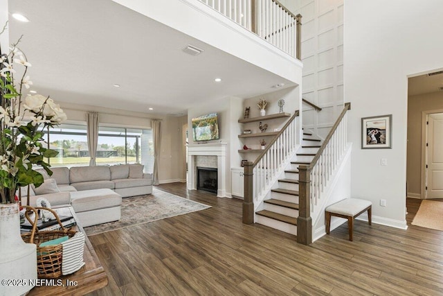 105 Awlleaf Ct, Saint Augustine, FL 32095 - living room with stairs, wood finished floors, a fireplace, a towering ceiling, and recessed lighting