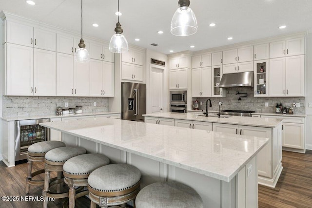 105 Awlleaf Ct, Saint Augustine, FL 32095 - kitchen with stainless steel appliances, a kitchen island with sink, under cabinet range hood, beverage cooler, and tasteful backsplash