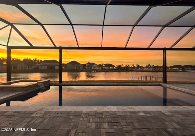 105 Awlleaf Ct, Saint Augustine, FL 32095 - pool at dusk featuring a water view, glass enclosure, and a pool with connected hot tub