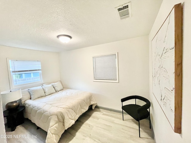 7381 Fernandina Ave, Jacksonville, FL 32208 - bedroom with light wood-type flooring, a textured ceiling, and baseboards