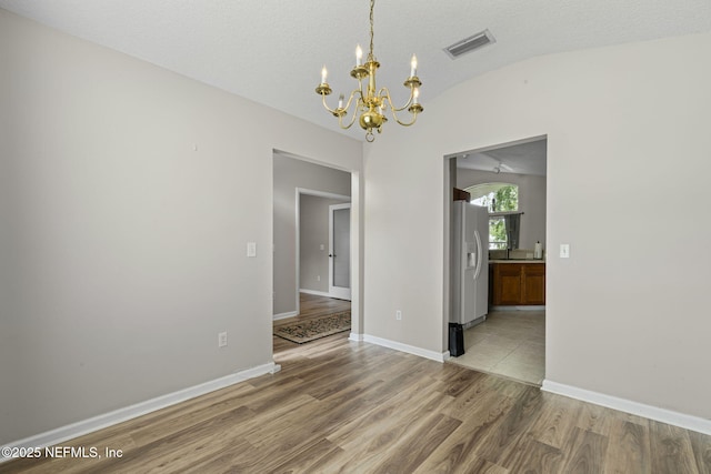 1608 Rustling Dr, Fleming Island, FL 32003 - unfurnished room with lofted ceiling, a chandelier, wood finished floors, and baseboards