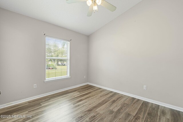 1608 Rustling Dr, Fleming Island, FL 32003 - spare room with wood finished floors, a ceiling fan, baseboards, and vaulted ceiling
