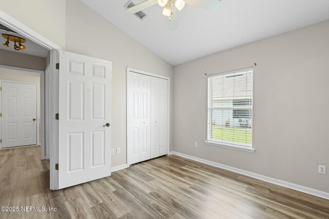 1608 Rustling Dr, Fleming Island, FL 32003 - unfurnished bedroom featuring vaulted ceiling, wood finished floors, a closet, baseboards, and a ceiling fan