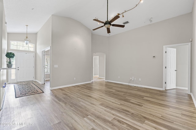 1608 Rustling Dr, Fleming Island, FL 32003 - foyer with high vaulted ceiling, a ceiling fan, arched walkways, light wood finished floors, and baseboards