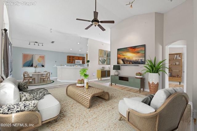 1608 Rustling Dr, Fleming Island, FL 32003 - living room featuring arched walkways, wood finished floors, ceiling fan, baseboards, and lofted ceiling