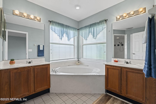 1608 Rustling Dr, Fleming Island, FL 32003 - bathroom featuring healthy amount of natural light, a garden tub, two vanities, and walk in shower
