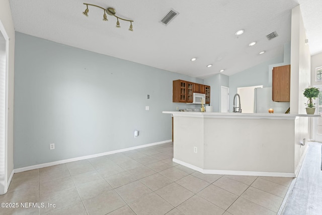1608 Rustling Dr, Fleming Island, FL 32003 - kitchen featuring white appliances, brown cabinetry, light tile patterned flooring, glass insert cabinets, and lofted ceiling