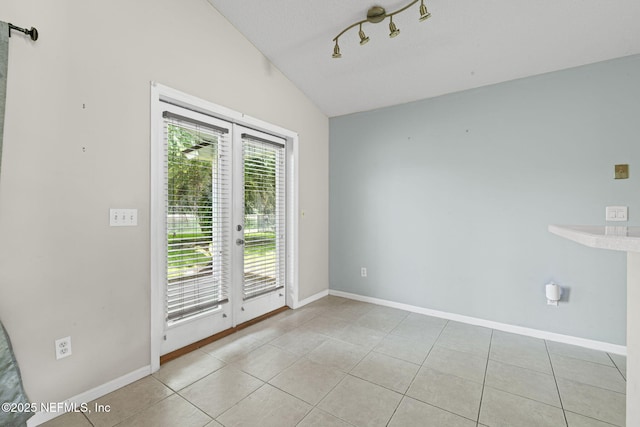 1608 Rustling Dr, Fleming Island, FL 32003 - empty room with vaulted ceiling, light tile patterned floors, baseboards, and rail lighting