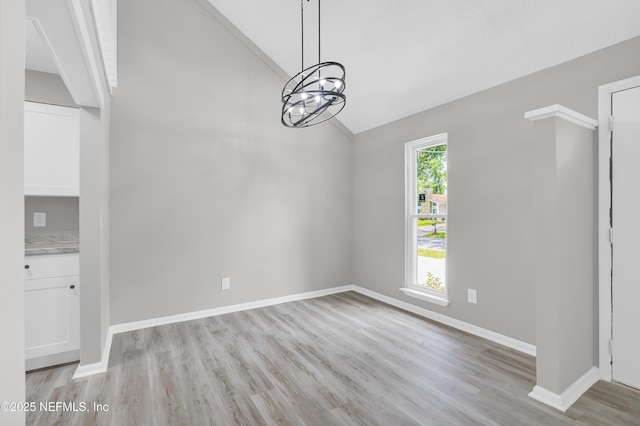 8687 Bishopswood Dr, Jacksonville, FL 32244 - unfurnished dining area featuring lofted ceiling, light wood-type flooring, and a chandelier