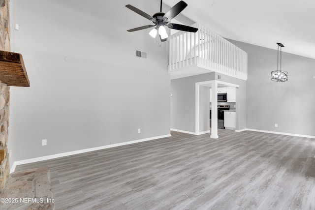 8687 Bishopswood Dr, Jacksonville, FL 32244 - unfurnished living room featuring high vaulted ceiling, a ceiling fan, light wood finished floors, and a chandelier