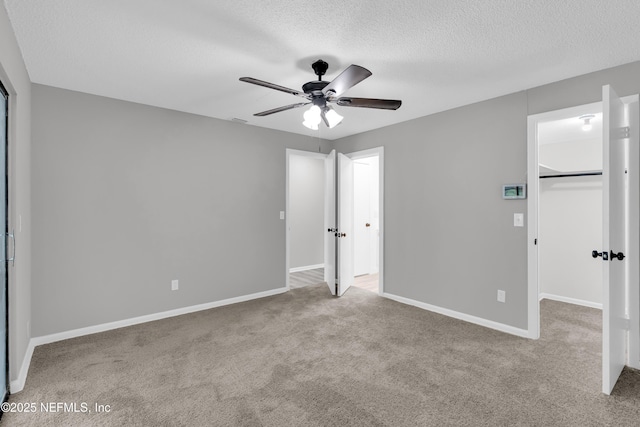 8687 Bishopswood Dr, Jacksonville, FL 32244 - unfurnished bedroom with carpet flooring, a walk in closet, a textured ceiling, a closet, and ceiling fan