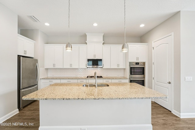 68 Briar Ridge Ct, Ponte Vedra, FL 32081 - kitchen featuring stainless steel appliances, decorative backsplash, dark wood-type flooring, white cabinetry, and an island with sink