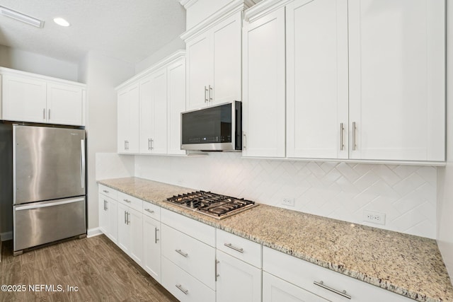 68 Briar Ridge Ct, Ponte Vedra, FL 32081 - kitchen with stainless steel appliances, tasteful backsplash, white cabinets, wood finished floors, and recessed lighting