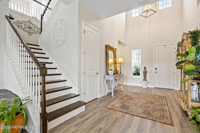 37 Permit Ct, Saint Augustine, FL 32092 - foyer entrance with stairway, a towering ceiling, a chandelier, and wood finished floors