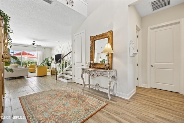 37 Permit Ct, Saint Augustine, FL 32092 - foyer entrance featuring stairway, a ceiling fan, light wood-type flooring, and a textured ceiling