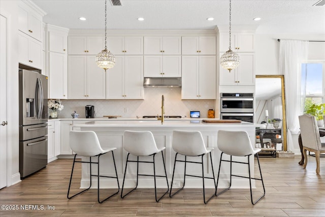 37 Permit Ct, Saint Augustine, FL 32092 - kitchen with stainless steel appliances, under cabinet range hood, white cabinets, pendant lighting, and recessed lighting