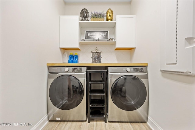 37 Permit Ct, Saint Augustine, FL 32092 - laundry room featuring independent washer and dryer, cabinet space, and light wood-style flooring