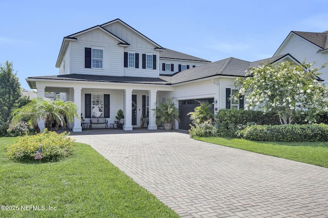 37 Permit Ct, Saint Augustine, FL 32092 - view of front of house featuring an attached garage, a porch, decorative driveway, board and batten siding, and a front lawn