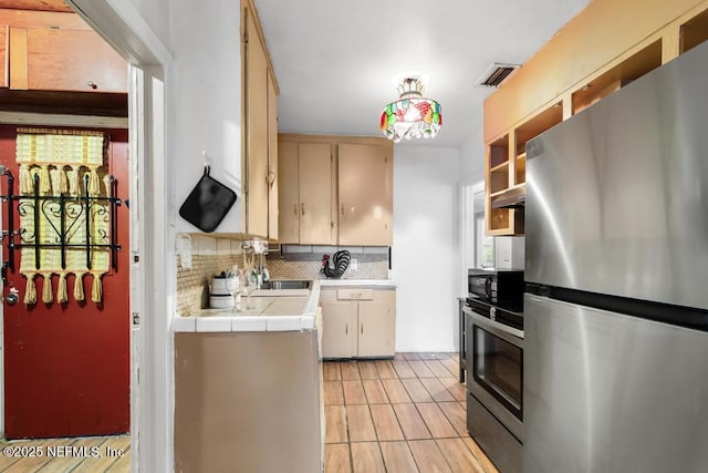 433 W 70th St, Jacksonville, FL 32208 - kitchen featuring freestanding refrigerator, tile countertops, and backsplash