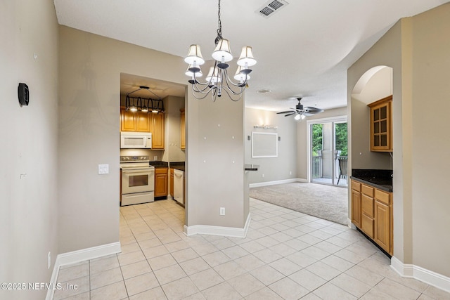 8601 Beach Blvd Unit 507, Jacksonville, FL 32216 - kitchen with white appliances, dark countertops, open floor plan, arched walkways, and a chandelier