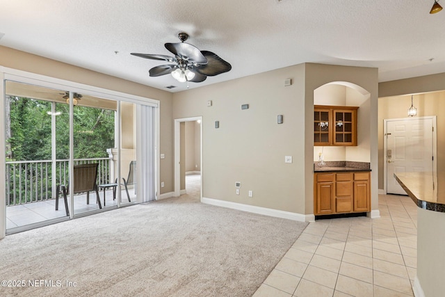 8601 Beach Blvd Unit 507, Jacksonville, FL 32216 - living room with a ceiling fan, baseboards, light tile patterned floors, a textured ceiling, and light carpet