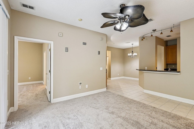 8601 Beach Blvd Unit 507, Jacksonville, FL 32216 - unfurnished living room featuring light colored carpet, a chandelier, ceiling fan, light tile patterned floors, and rail lighting
