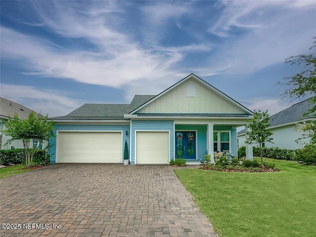 95191 Poplar Way, Fernandina Beach, FL 32034 - view of front of house with board and batten siding, an attached garage, decorative driveway, a front lawn, and a porch