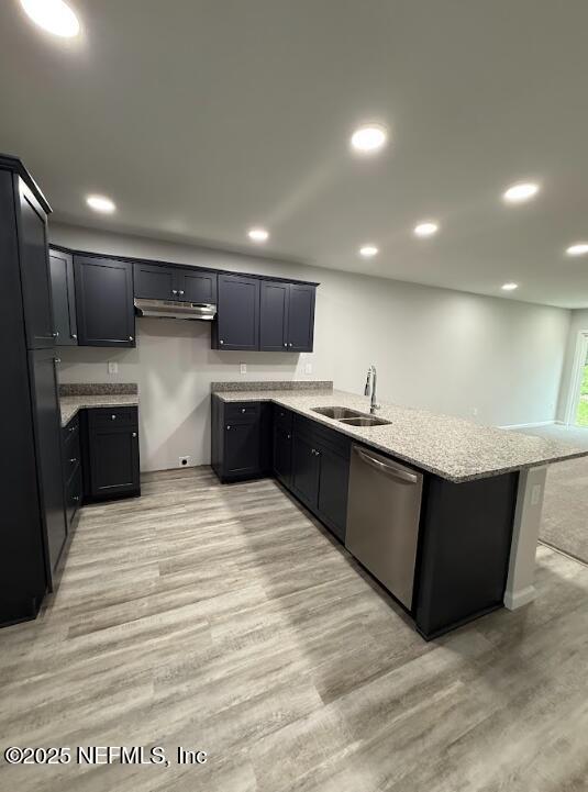 8051 Driggers St, Jacksonville, FL 32220 - kitchen featuring dishwasher, a sink, under cabinet range hood, a peninsula, and light stone countertops