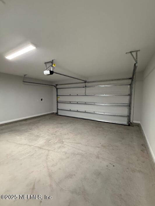 8051 Driggers St, Jacksonville, FL 32220 - garage featuring baseboards and a garage door opener