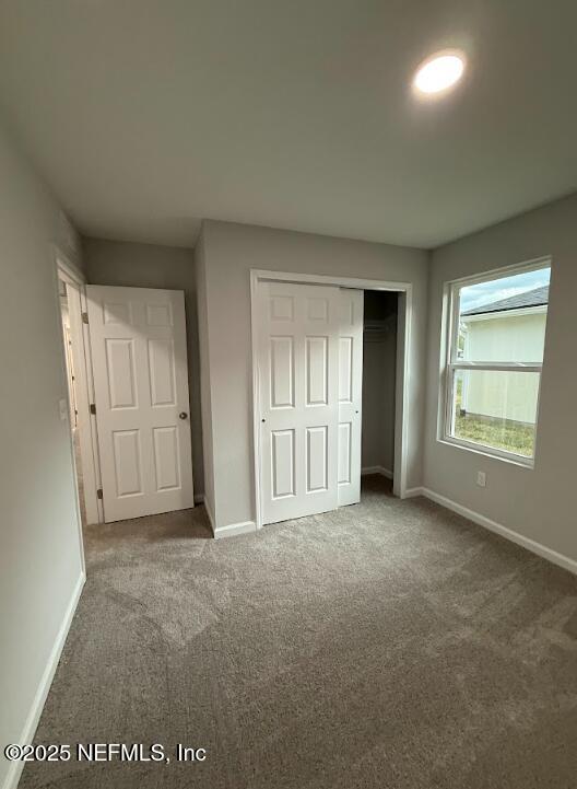 8051 Driggers St, Jacksonville, FL 32220 - unfurnished bedroom featuring baseboards, carpet flooring, and a closet