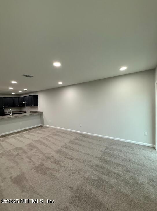 8051 Driggers St, Jacksonville, FL 32220 - unfurnished living room featuring carpet flooring, baseboards, and recessed lighting