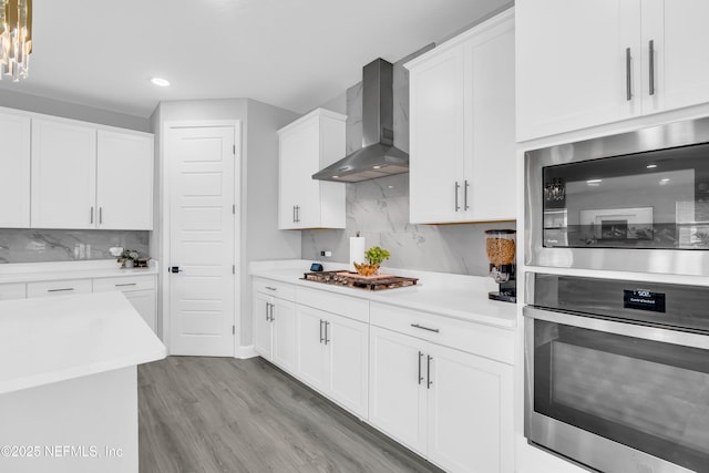 194 Napo Way, Saint Johns, FL 32259 - kitchen featuring appliances with stainless steel finishes, wall chimney range hood, backsplash, light wood-type flooring, and light countertops