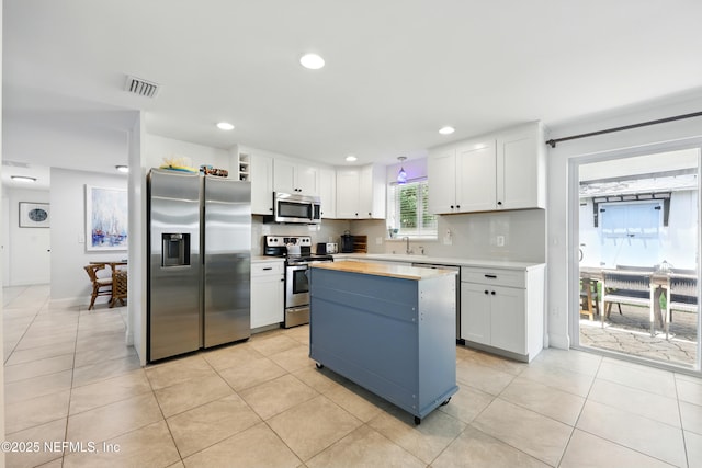 2734 Colonies Dr, Jacksonville Beach, FL 32250 - kitchen featuring stainless steel appliances, white cabinets, a center island, light tile patterned floors, and recessed lighting