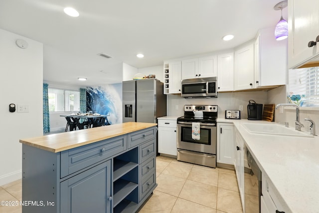 2734 Colonies Dr, Jacksonville Beach, FL 32250 - kitchen with stainless steel appliances, a sink, open shelves, white cabinets, and recessed lighting