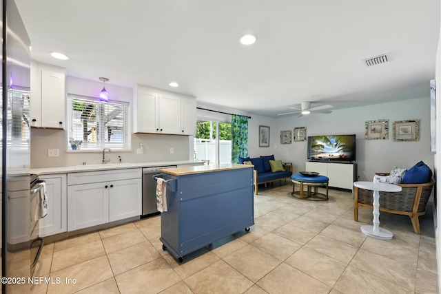 2734 Colonies Dr, Jacksonville Beach, FL 32250 - kitchen with stainless steel appliances, a sink, white cabinets, light countertops, and ceiling fan