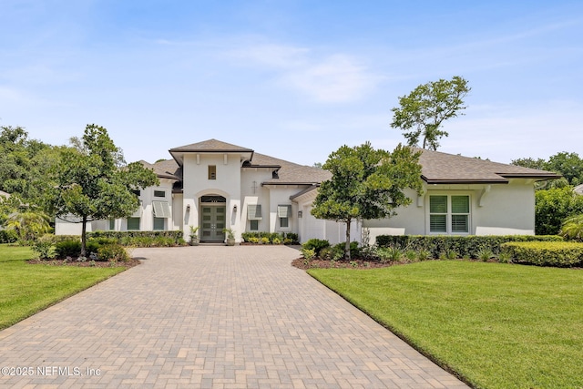 1332 N Loop Pkwy, Saint Augustine, FL 32095 - view of front facade with french doors, decorative driveway, stucco siding, and a front yard